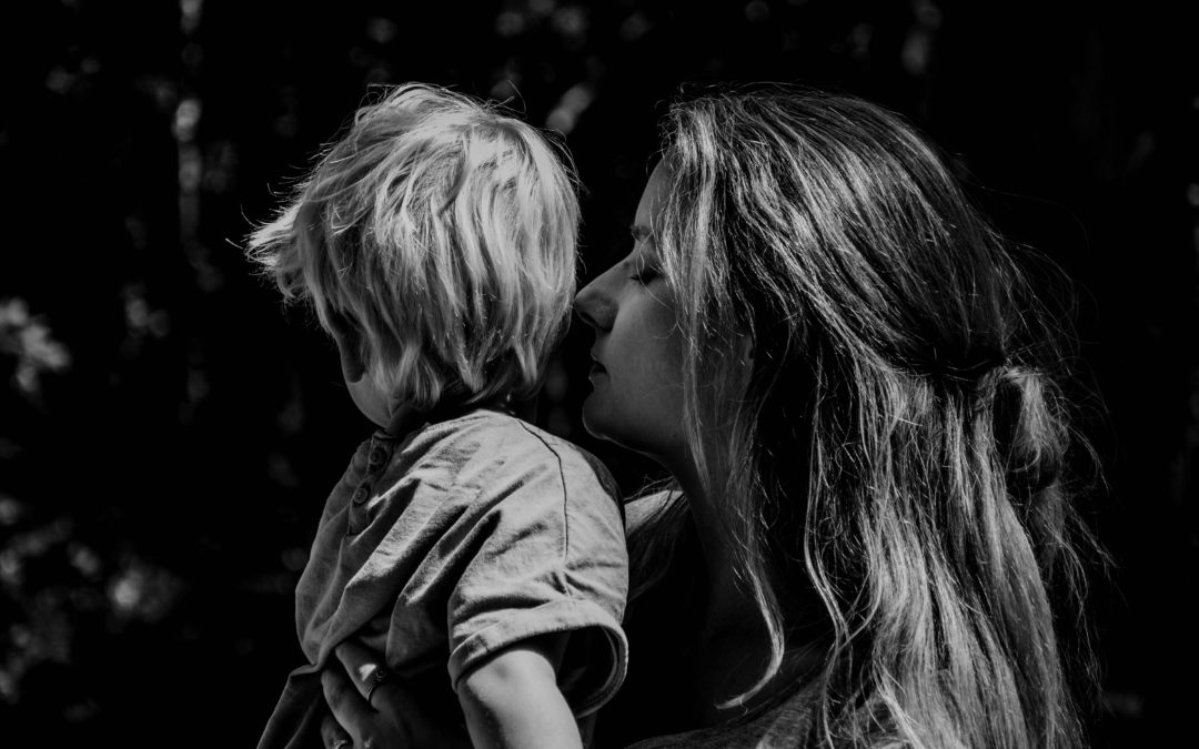 Woman Kissing Son Who Is Looking Away